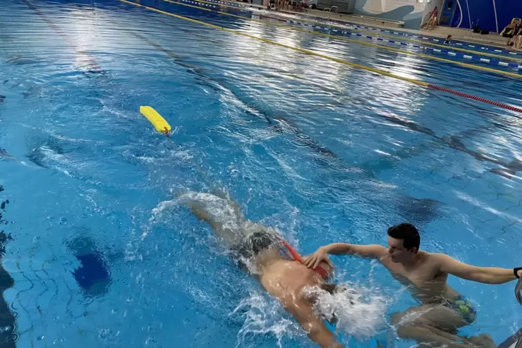 Es muss schnell gehen: Linas Orth (links) schwimmt mit Gurtretter zu Fabian Rudorf. Der &uuml;bernimmt den Gurtretter.