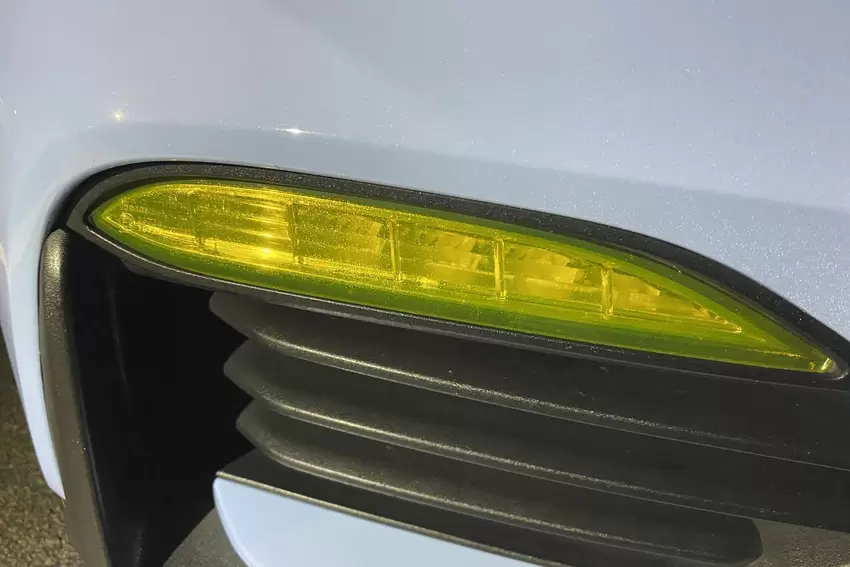 Illegale gelbe Folie über dem Scheinwerfer.