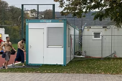 Sie trotzen der Kälte: VfL-Fußballer laufen im Handtuch bekleidet von der Umkleide (hinten links) zum Duschcontainer (rechts).