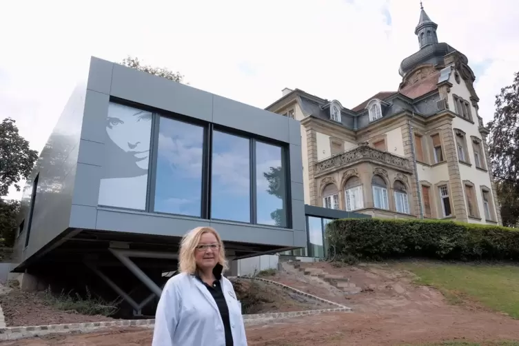 Dauermieterin Eva Lang 2020 vor dem futuristisch anmutenden OP-Saal, der mit der alten Villa &uuml;ber einen gl&auml;sernen Gang verbunden