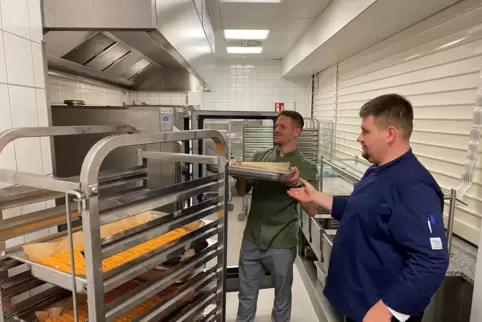 Benjamin Hassenpflug (hinten) und Roger Fruck schieben die Fischstäbchen in den Konvektomat. Bis zu 600 Gerichte richten sie täg