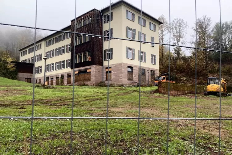 Blick durch den Bauzaun auf das Hauptgeb&auml;ude.