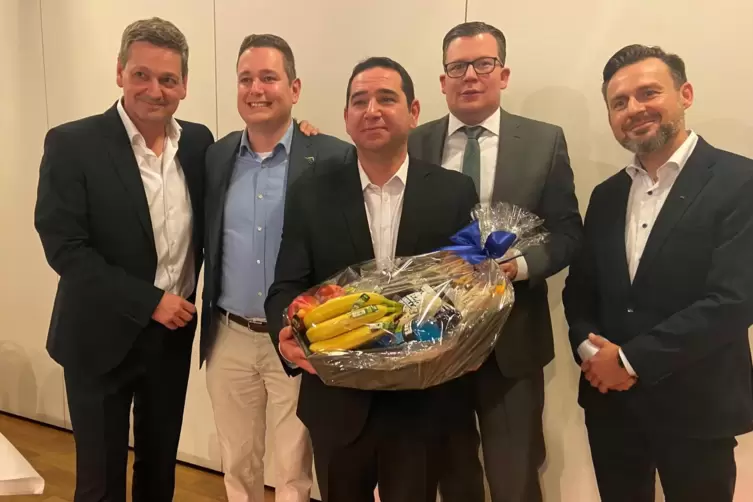 Sertac Bilgin mit einem Geschenkkorb, der ihm Energie verleihen soll. An seiner Seite von links: Versammlungsleiter Christian Ba