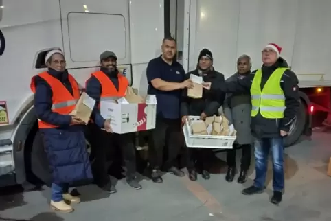 Ein Lastwagenfahrer aus Polen (Bildmitte) freut sich über eine kleine Geschenktüte.