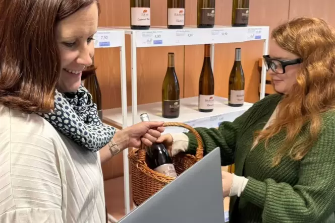 Sandra Morsch (links) erklärt Franziska Fuchs vor dem präparierten Weinregal, wie die Eye-Tracking-Brille funktioniert.