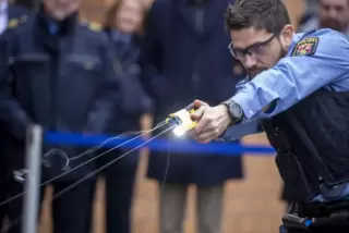 Der Taser verschießt zwei Pfeile, die an dünnen Drähten hängen. Das Rauchfähnchen stammt vom Treibgas Stickstoff. Laserstrahlen 