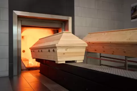 Ein Sarg fährt im Krematorium in die Verbrennung. 