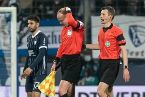  Assistent Christian Gittelmann (Mitte) verlässt das Spielfeld, nachdem er in Bochum einen Becher an den Kopf bekommen hatte. Da