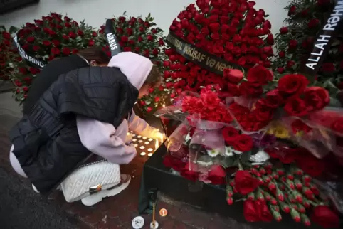 Eine Frau gedenkt in Baku des Piloten, der bei dem Absturz ums Leben kam.
