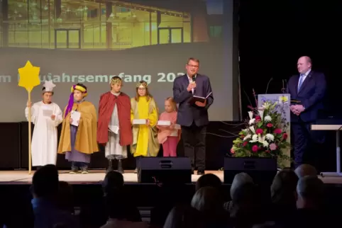 Die Sternsinger und Diakon Claus Kasper spendeten der Gemeinde mit Bürgermeister Thorsten Leva (rechts) an der Spitze den Segen 