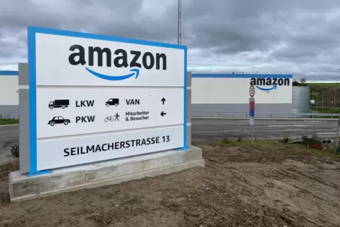 An der Halle prangt das bekannte Firmenlogo, und an der Zufahrt steht ein großes Adressschild.