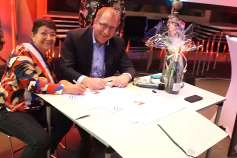 Beatrix Lacroix Mfouara und Thorsten Bechtel unterzeichnen 2023 die neue Partnerschaftsurkunde.