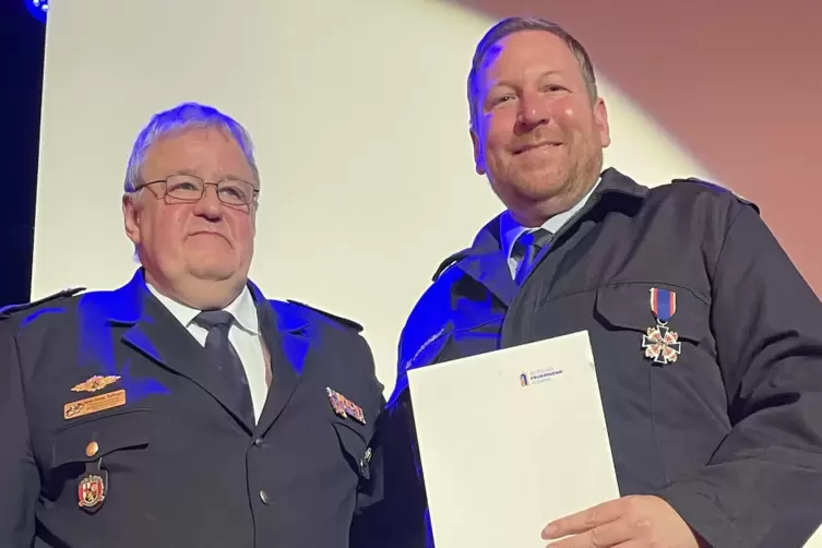 Hans-Georg Balthasar, Vorsitzender des Regionalen Feuerwehrverbandes (links), &uuml;berreichte Mike Sch&ouml;nlaub (rechts) das Feuerwehr-