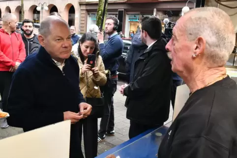 Bundeskanzler Olaf Scholz (SPD) lässt sich zur Mittagspause eine Currywurst am St. Ingberter Holzkohlegrill „Zum Schleppi“ schme