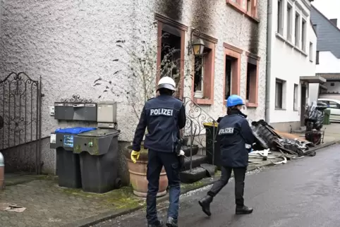 Polizisten untersuchen das Wohnhaus in Saarbrücken-Jägersfreude, in dem das Feuer ausgebrochen war. 