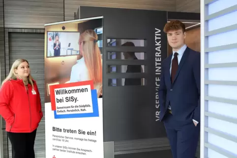 Michelle Bauer und Max Auras erklären Kunden der Sparkasse Südpfalz und VR-Bank Südpfalz Sisy.