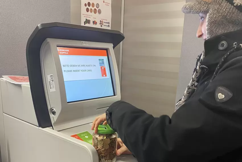 »Okay, dann eben der andere Münzgeldautomat.« Wir testen den Münzeinzahler der Sparkasse – mit einem prallgefüllten Glas voller