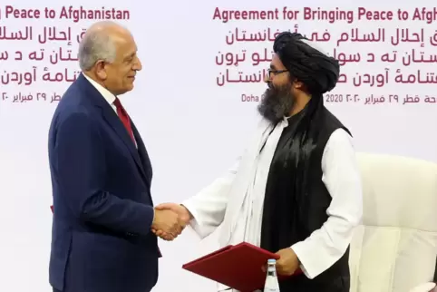 Zalmay Khalilzad (links), der US-Sondergesandte, und Mullah Abdul Ghani Baradar, nach der Unterzeichnung des Abkommens über eine