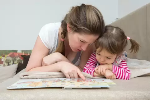 Gemeinsam ein Bilderbuch anschauen ist eine von vielen Möglichkeiten, Kinder im Alltag spielerisch an Sprache heranzuführen. 