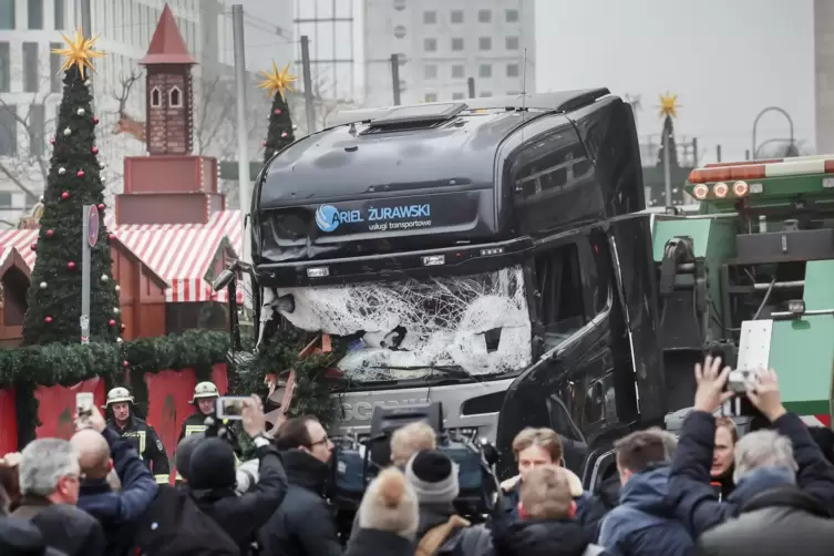 Schaulustige und Reporter stehen um die Tatwaffe auf dem Berliner Weihnachtsmarkt: Ein gestohlener Lkw.