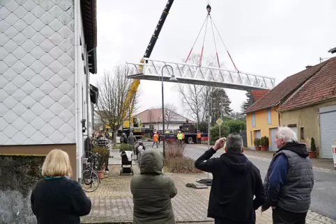 Die neue Bliesbrücke wird vom Tieflader über die Häuserdächer gehoben, und dann wieder aufgeladen. Grund war eine tückische Kurv