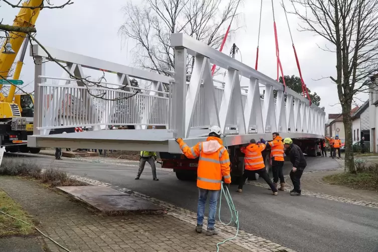 Die zw&ouml;lf Tonnen schwere Br&uuml;cke wird in Wolfersheim an der Ecke Wolfharistra&szlig;e und Breitfurter Weg umgesetzt. 50 Einwohner feier