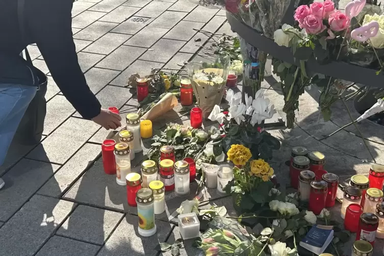 Passanten z&uuml;nden an dem Gedenkort am Paradeplatz Kerzen an.