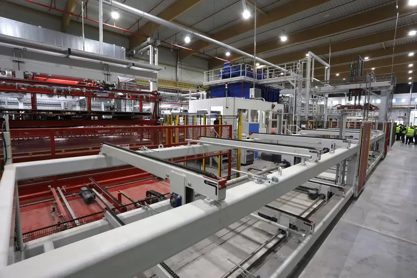 Blick in die Werkhalle mit der 2022 in Betrieb genommenen neuen Beschichtungsanlage für Spanplatten.