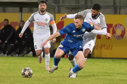 Torschütze Luca Eichhorn (in Blau) beim Zweikampf mit dem Ludwigshafener Wal Fall. Im Hintergrund schaut FCA-Kapitän Nico Pantan