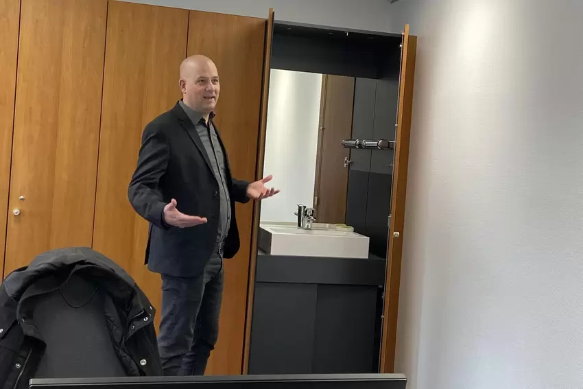 Hinter der Schranktür versteckt sich ein Waschbecken: Martin Brandl zeigt die Ausstattung im ehemaligen Büro des Sparkassen-Vors