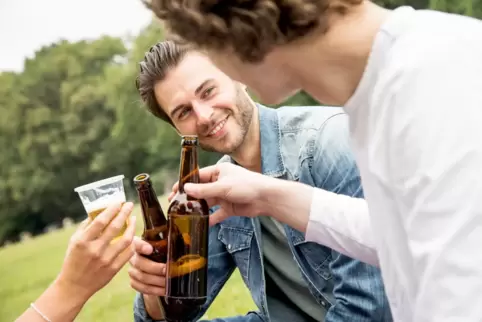 Zwei Männer stoßen mit Bier an.