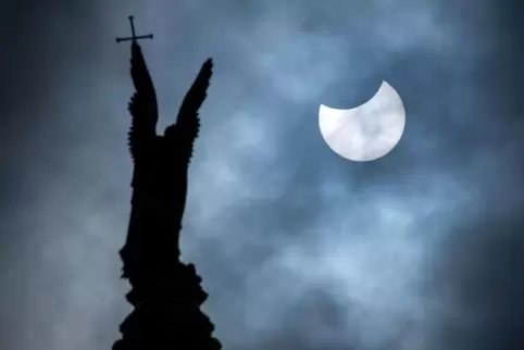 Eine partielle Sonnenfinsternis ist über der vergoldete Statue des Erzengel Michael auf der Kuppel des Schweriner Schlosses zu s