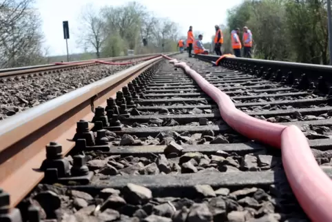 Arbeiter sind an der Bahngleise bei Landau schon am Werk, damit der Zugverkehr bald wieder rollen kann.