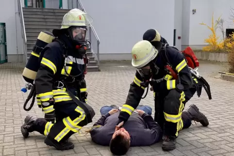 Tragen einen Verletzten aus dem Gefahrenbereich: Feuerwehrleute bei der Übung am Samstag im Freizeitbad Aquabella in Mutterstadt