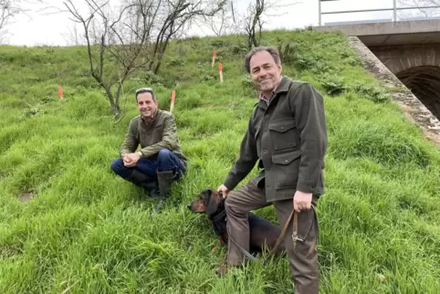 Jagdpächter Steven Menger (links) und Kreisgruppenvorsitzender Anton Negele mit Jagdhund Axel kennen die Dachsbauten im Bahndamm
