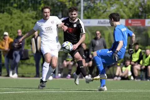 Neuhofens Torwart Lars Malmberg (rechts) klärt vor Bleard Zeqiraj (Mitte), Kickers-Akteur Alexander Bähr (links) kommt zu spät. 