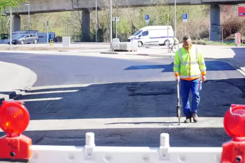 Mitarbeiter der Firma Eurovia tragen am Dienstag die Binderschicht auf die abgefräste Landauer Straße auf. 