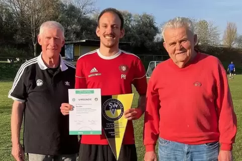 Ehrung auf dem Fußballplatz (von links): Andreas Gödtel, Ehrenamtsbeauftragter im Fußballkreis Kaiserslautern-Donnersberg, Paul 