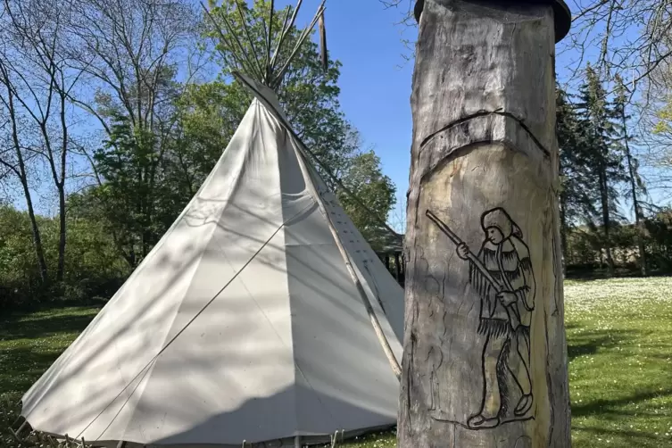 Liebevolle Details: das rund f&uuml;nf Meter hohe Tipi und ein selbstgeschnitzter Wegweiser.