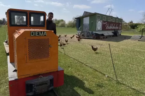 Georg Schmitt fährt mit der Feldbahn zu seinen Hühnerställen. Vor einigen Jahren hat er dafür Gleise über seine Wiese verlegt.