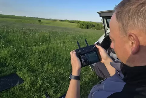 Pilot Christian Küntzler überfliegt die Wiese mit einer Drohne, die mit zwei Kameras ausgestattet ist, eine davon ist eine Wärme