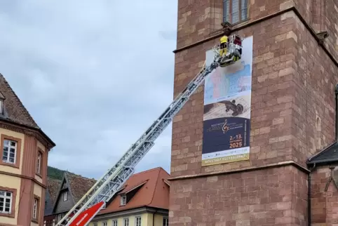 Fast geschafft: Das Plakat an der Stiftskirche muss noch befestigt werden.