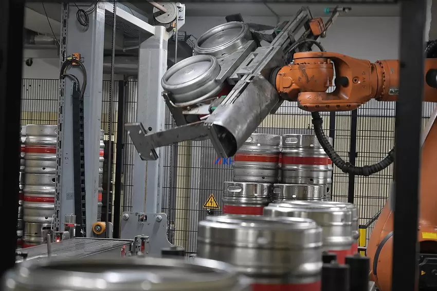 Der Roboterarm wuchtet bis zu 160 Fässer pro Stunde auf Paletten.