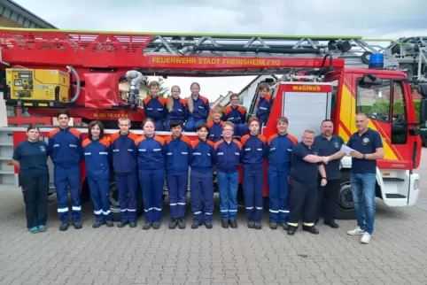 Andreas Lantz, Präsident des Lions-Club, übergibt der Jugendfeuerwehr Freinsheim die Spende vor dem Gerätehaus. 