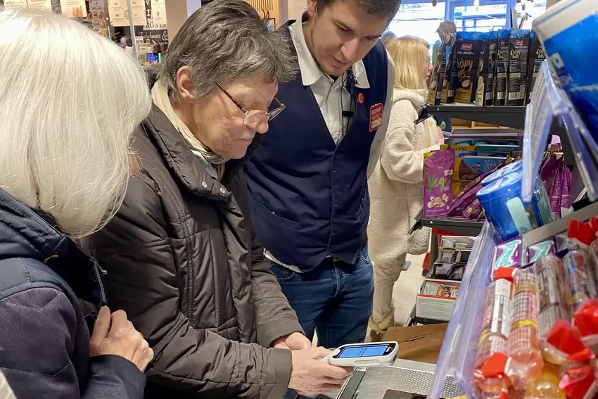 Nachdem Irene Hoffmann den Einkauf beendet hat, erscheint ein QR-Code auf dem Gerät, den sie auf der SB-Kasse einscannt.