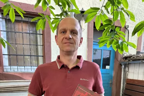 Dominik Bold mit dem Buch, das 125 Geschichten über 125 Jahre FCK enthält.