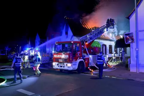 Die Flammen schlagen aus dem Dachstuhl: Die Feuerwehr löscht auch mithilfe einer Drehleiter. 