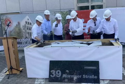 Altes Fassadenteil hat ausgedient: Projektbeteiligte beim symbolischen Hammerschlag.