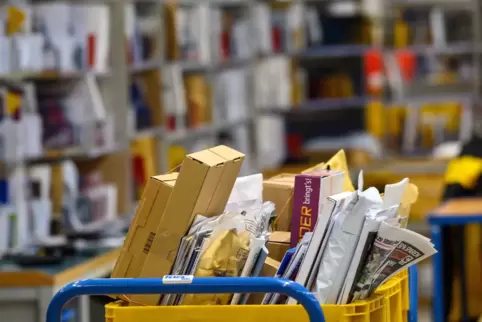 Im Zustellstützpunkt in Kusel stapeln sich Päckchen und Briefe, erzählt ein Postmitarbeiter. 