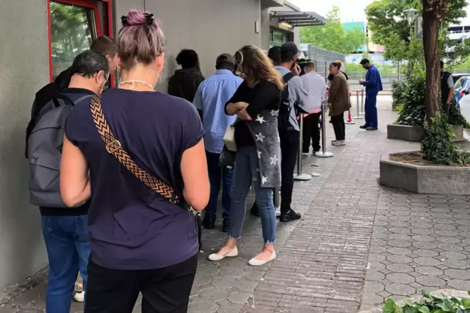 Warten auf dem Gehweg in der Mottstraße im Hemshof. Die Schlange derer, die ohne Termin in die Ausländerbehörde wollen, ist scho Warten auf dem Gehweg in der Mottstraße im Hemshof. Die Schlange derer, die ohne Termin in die Ausländerbehörde wollen, ist scho